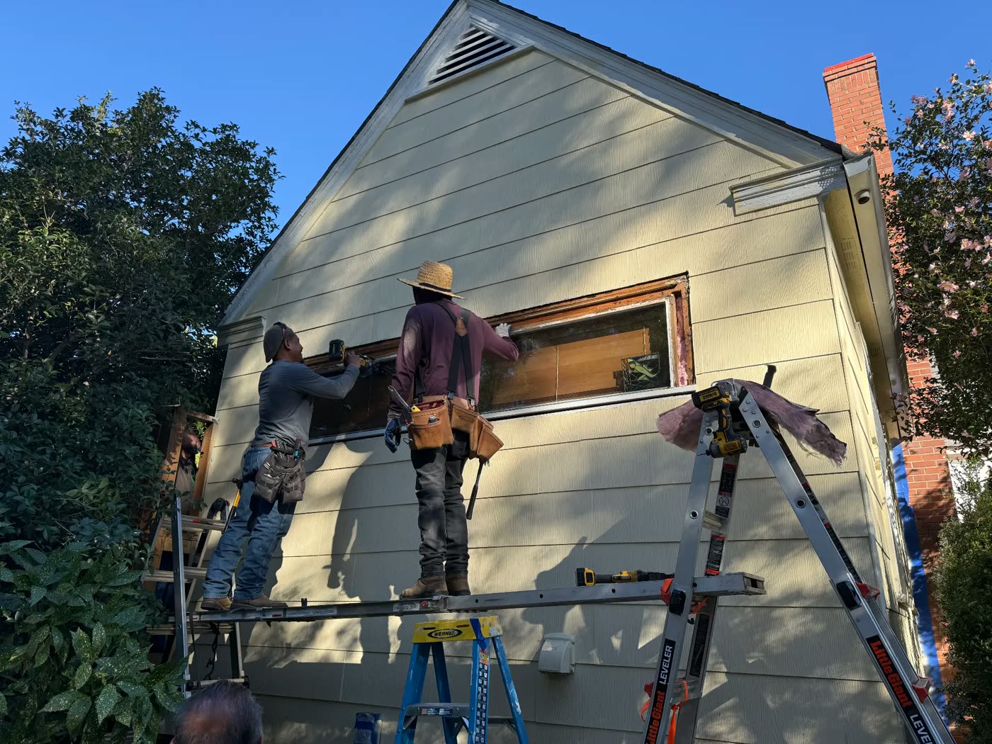 Crew completing siding and window carpentry repairs before exterior painting