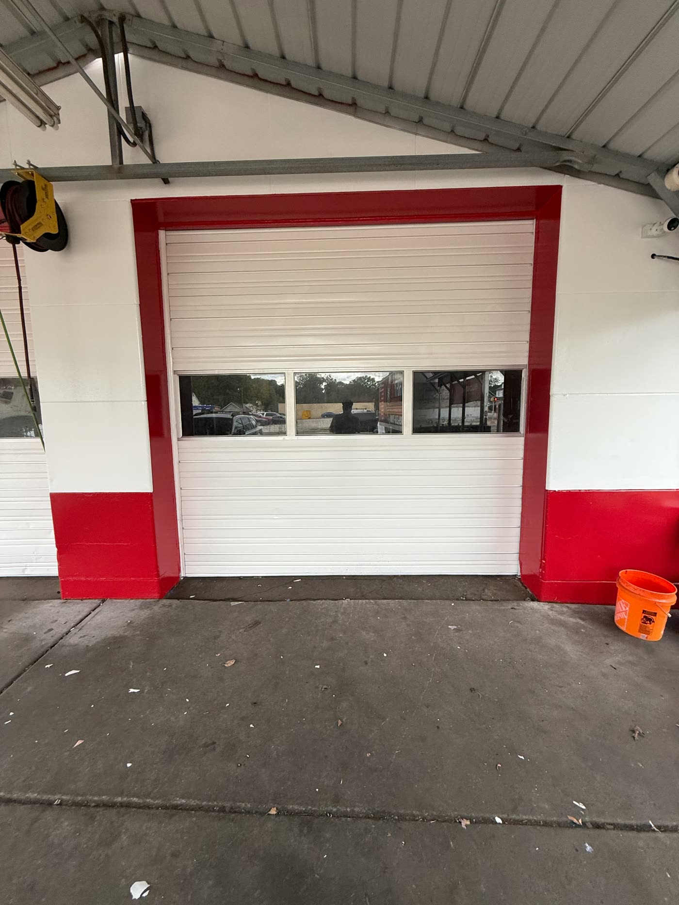 Service bay door with freshly painted white panels and red trim surround