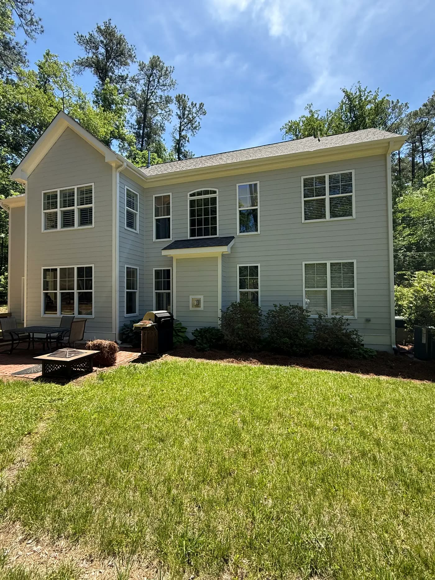 Two-story home rear exterior with freshly painted sage siding and white trim