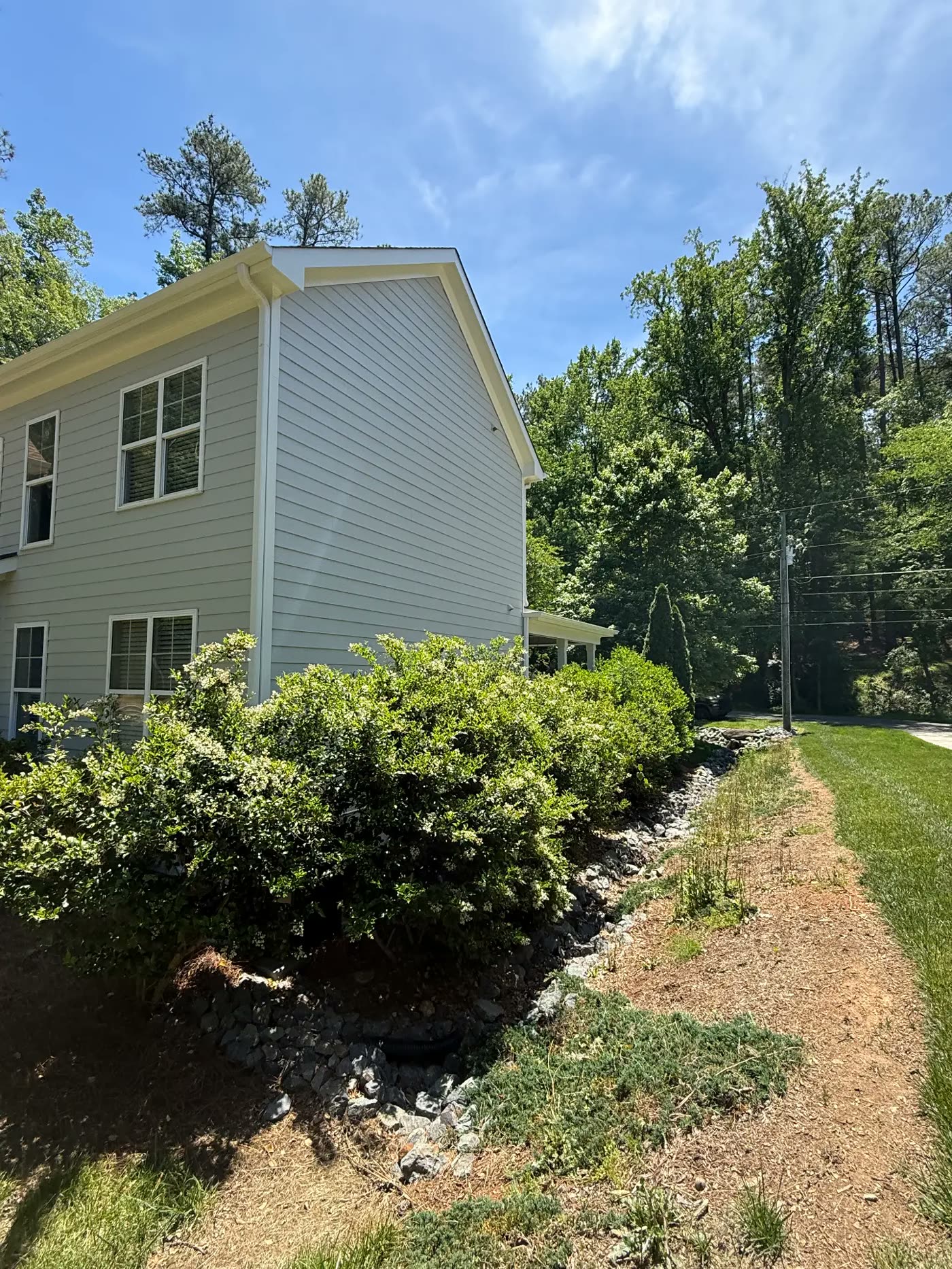 Side elevation of a home with fresh exterior paint and crisp white trim
