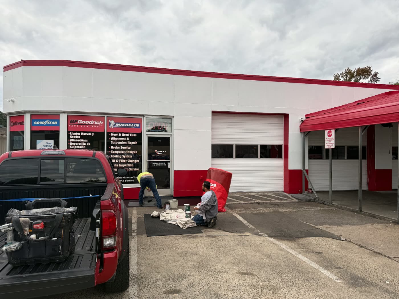 Commercial storefront repaint in progress with fresh white and red finish