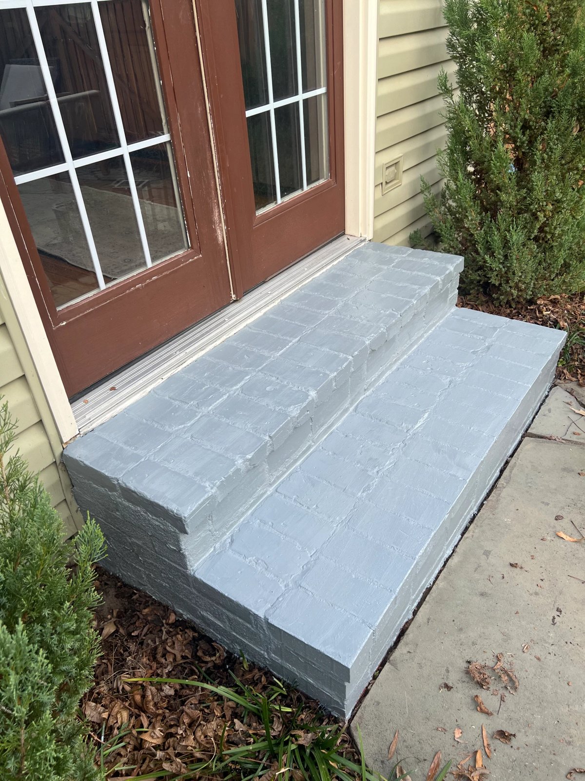 Brick entry steps freshly coated in durable gray porch paint