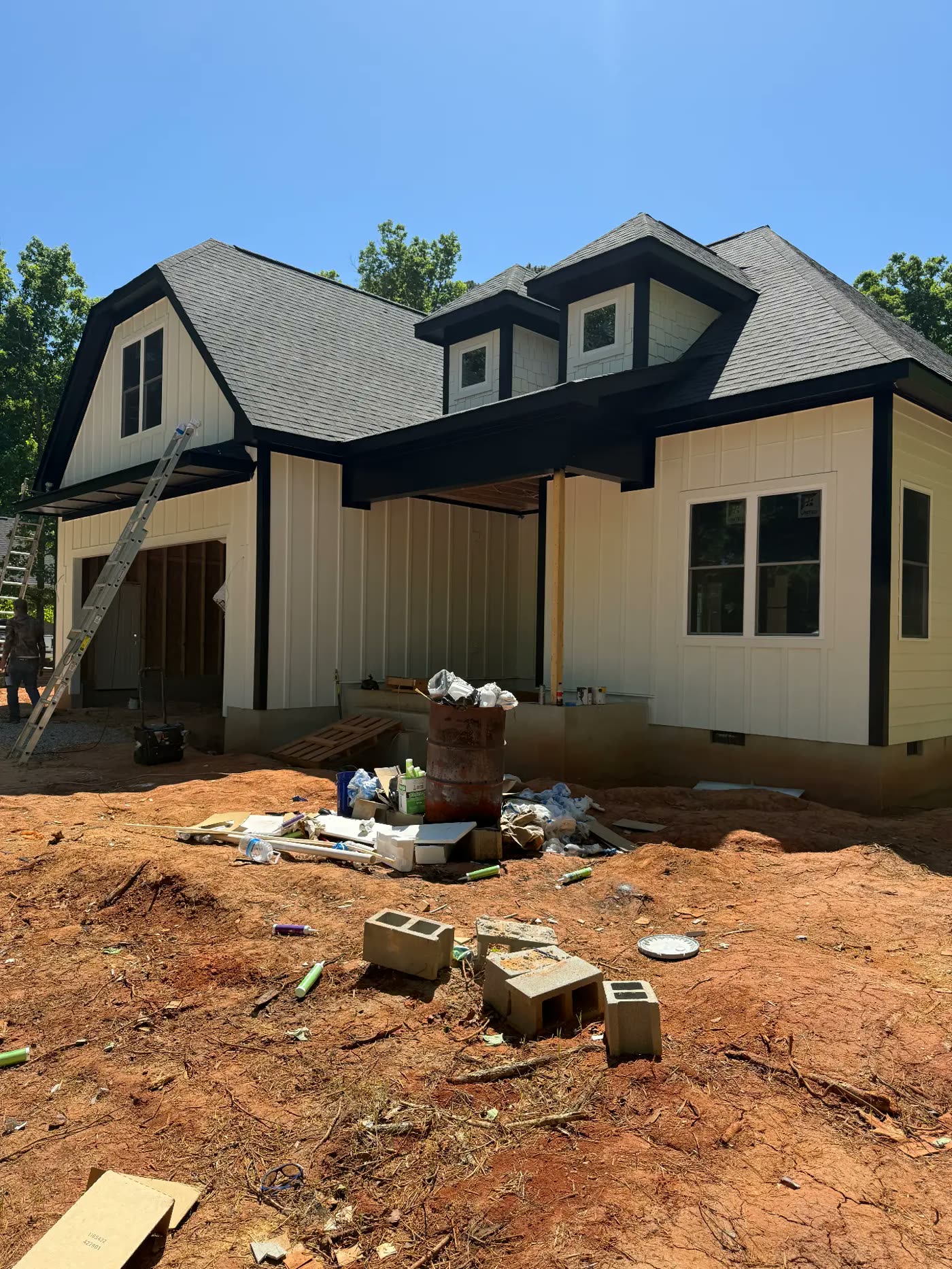 New construction home finished in cream board-and-batten with black trim