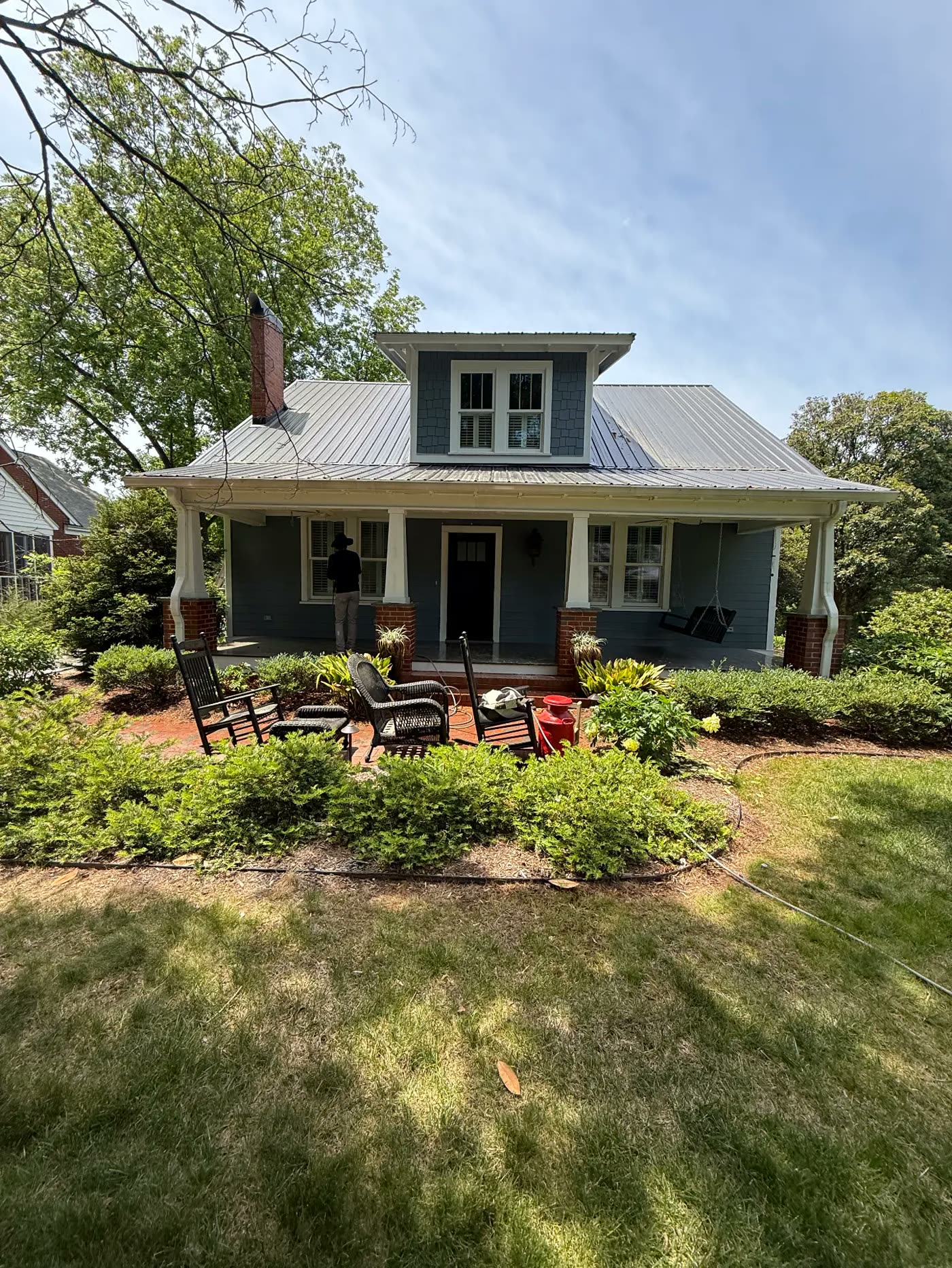 Craftsman bungalow with freshly painted blue-gray siding and white porch columns
