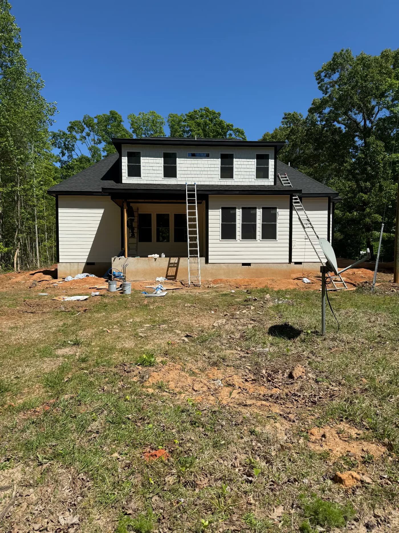 Rear elevation of a new build with fresh cream siding and dark trim