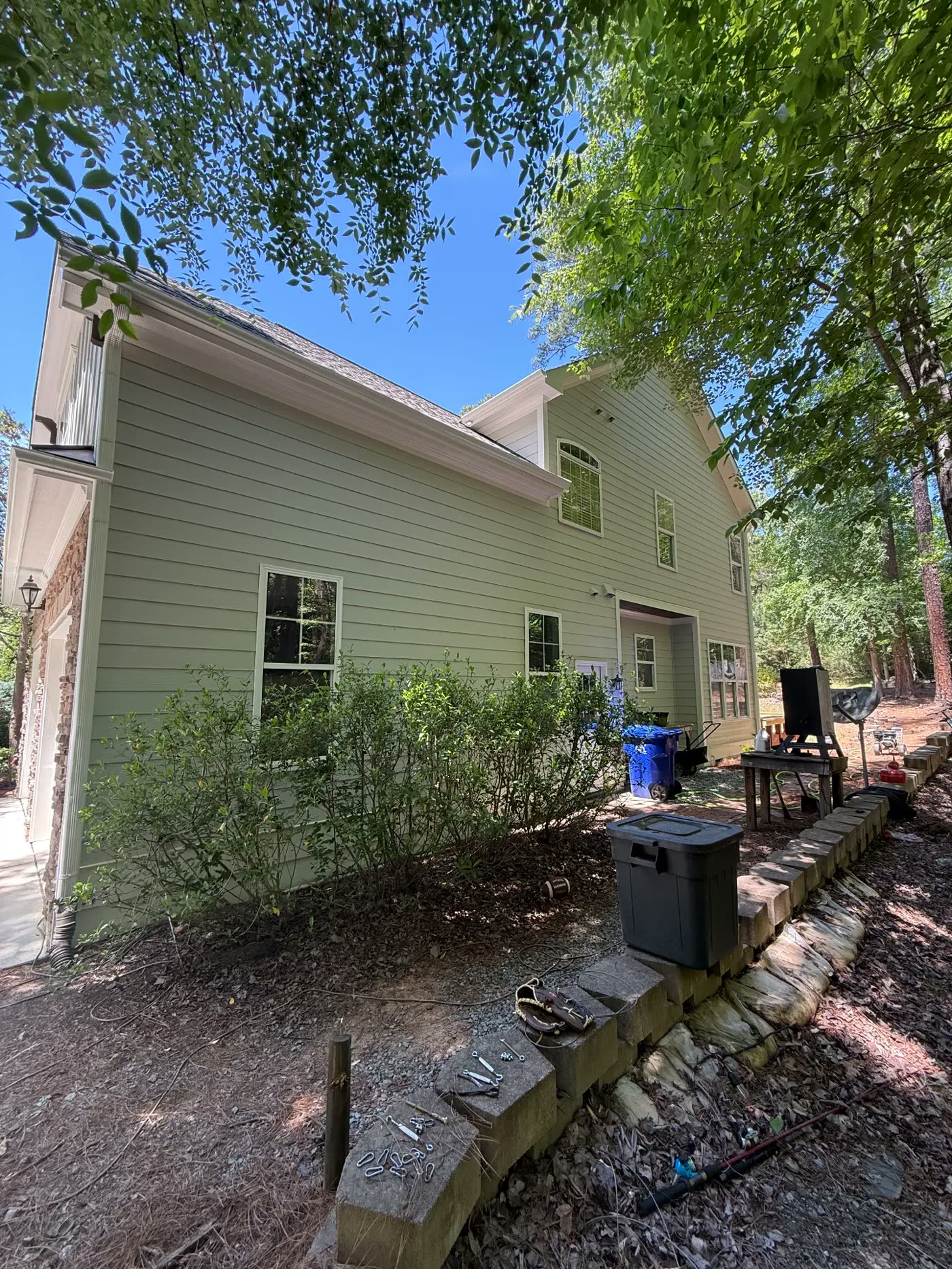 Two-story home with freshly painted sage green siding and white trim