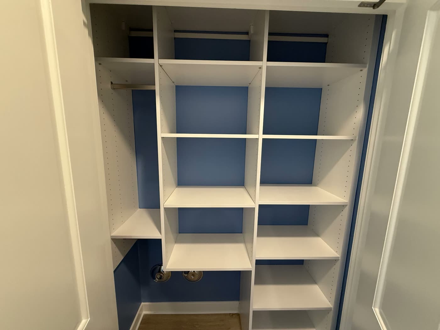 Closet interior painted blue with crisp white built-in shelving