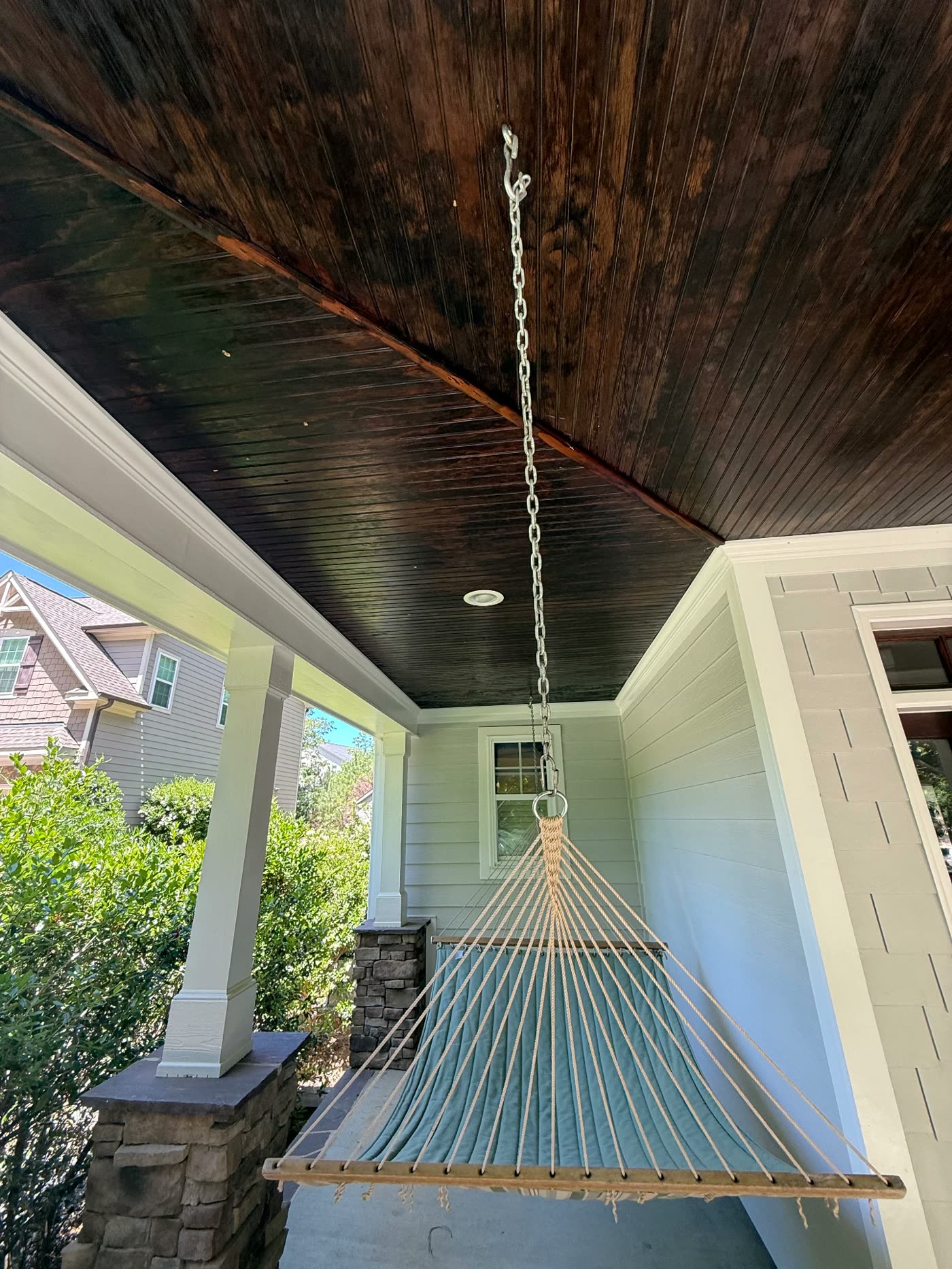Porch hammock beneath a freshly stained tongue-and-groove ceiling