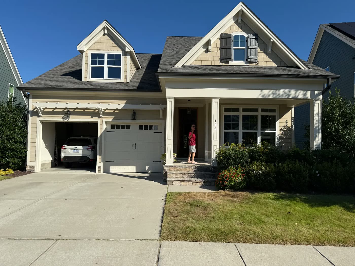 Craftsman home repainted in cream with white trim and dark shutters